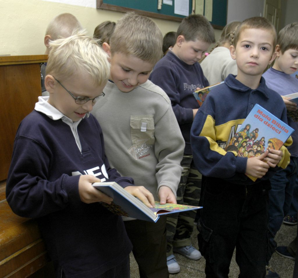 Kinderen bekijken de kinderbijbels die ze net hebben gekregen