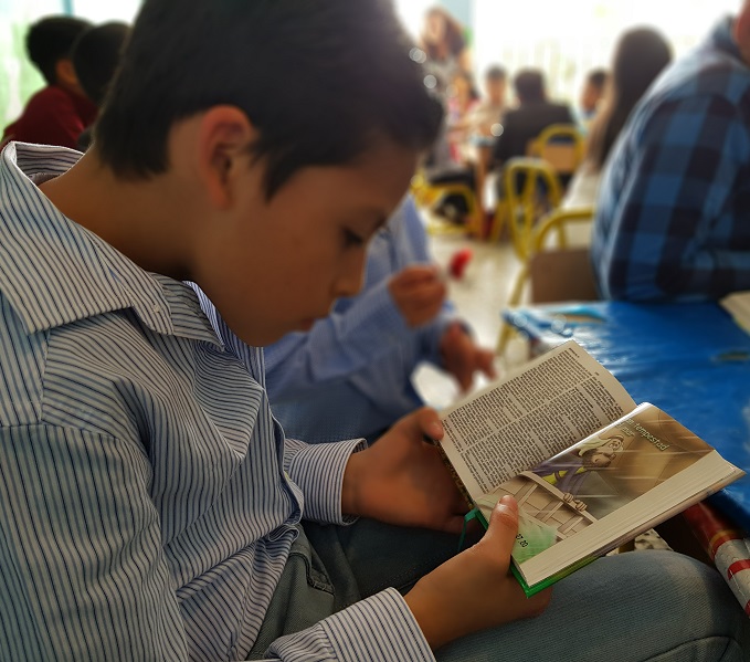 Een jongen in Guatemala leest in zijn Bijbel. 