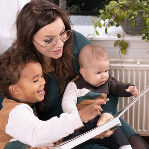 Moeder leest uit de Babybijbel met twee kinderen
