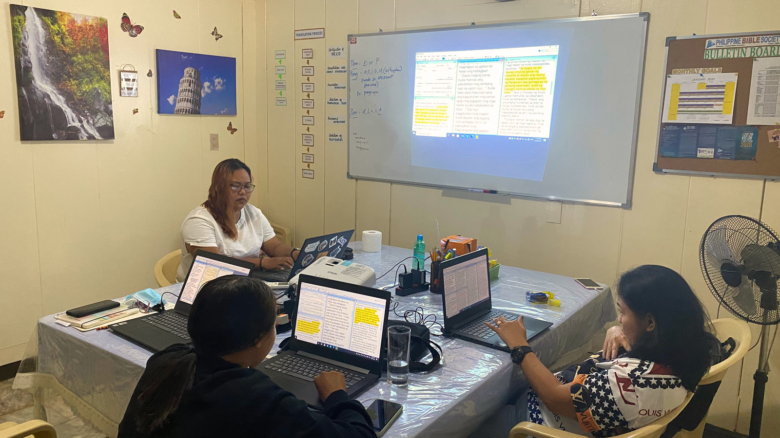 Bijbelvertalers in de Filipijnen kijken samen naar scherm.