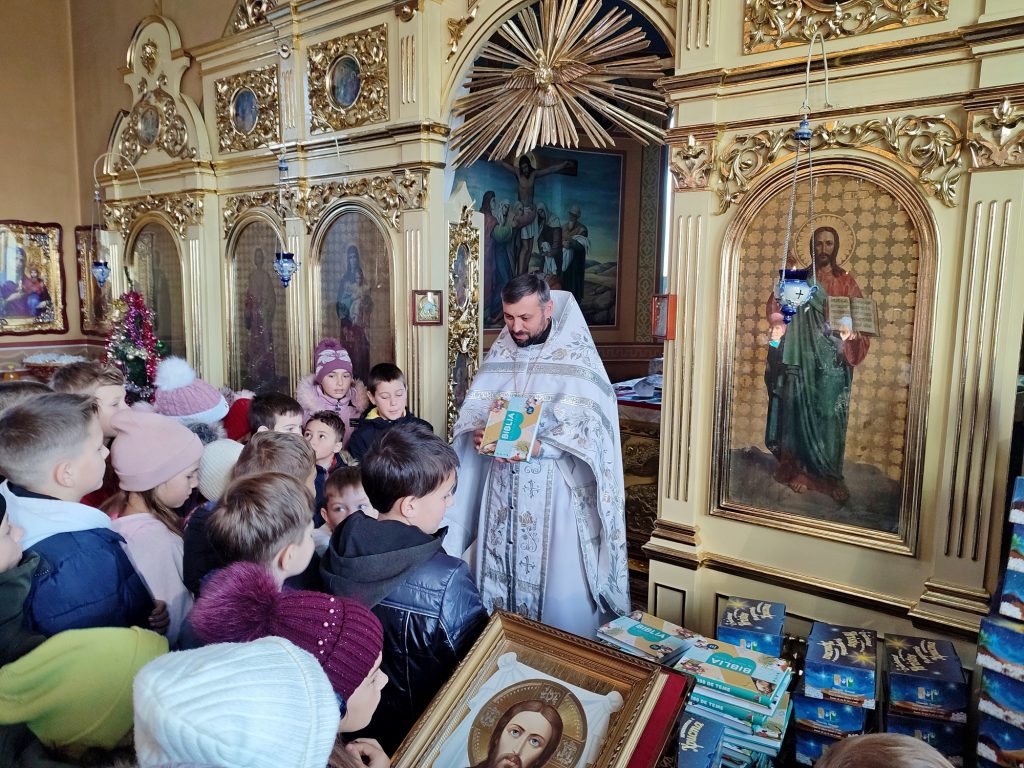 Bijbel wordt uitgedeeld door priester in orthodoxe kerk in Cruglic.