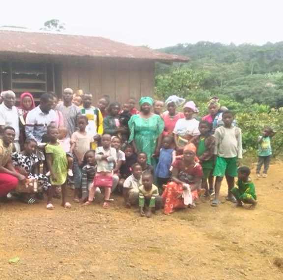 Een groep zwarte mensen in Ovala, Gabon, voor een gebouw.