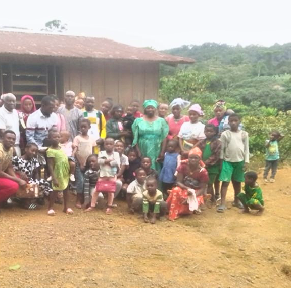 Een groep zwarte mensen in Ovala, Gabon, voor een  gebouw.