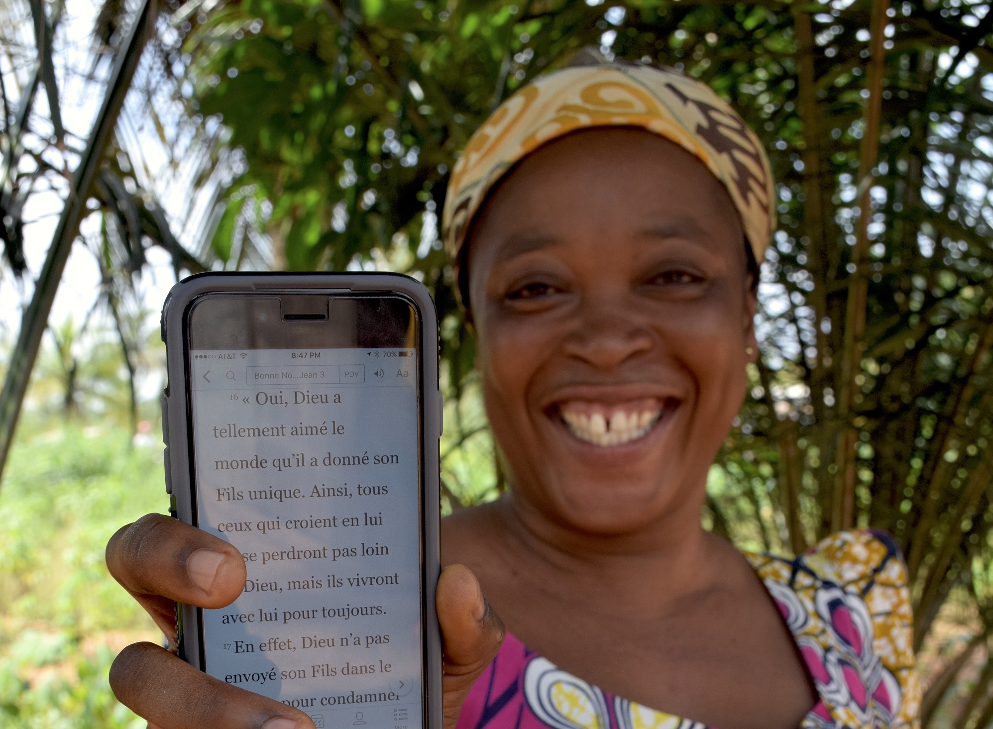 Zwarte vrouw laat mobiele telefoon met Bijbeltekst zien
