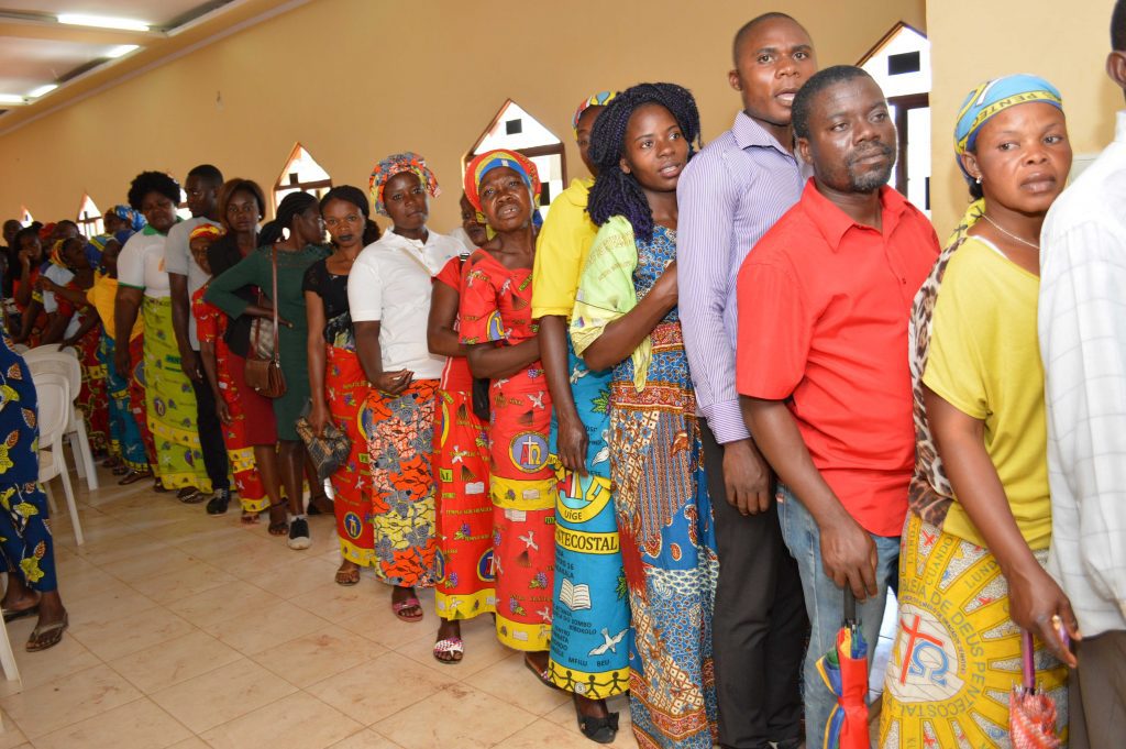 Angolezen staan in de rij om een nieuwe Testament te kopen.
