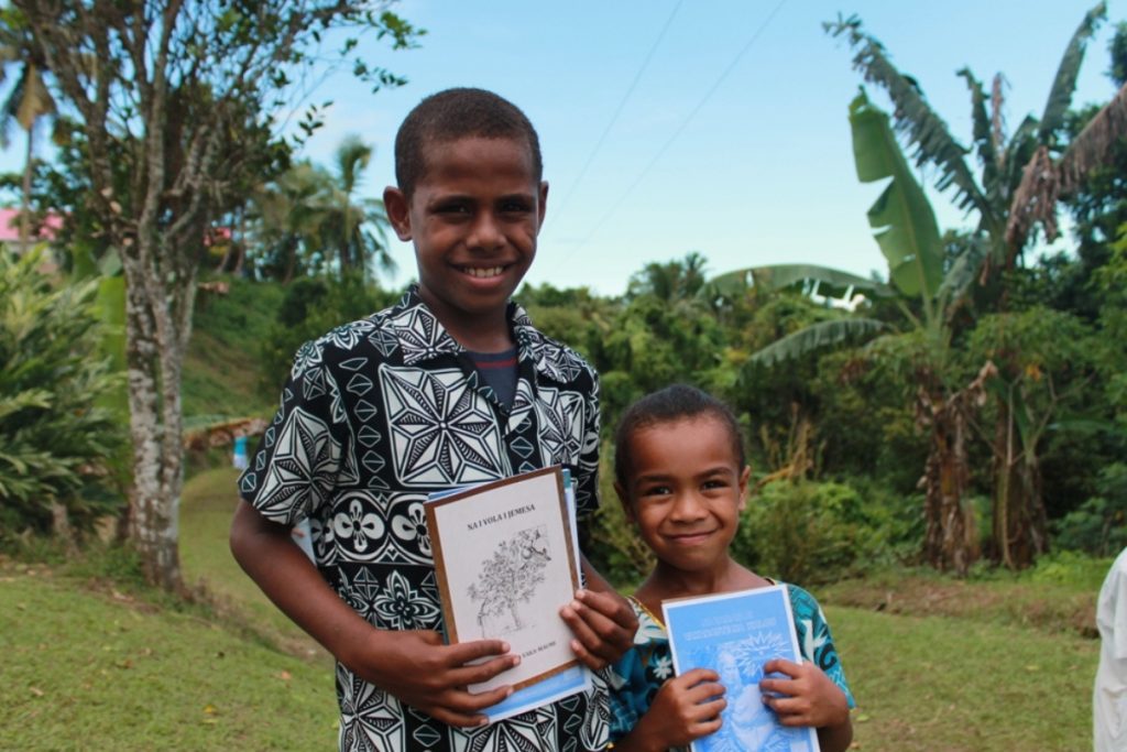 Twee kinderen met een Bijbelgedeelte