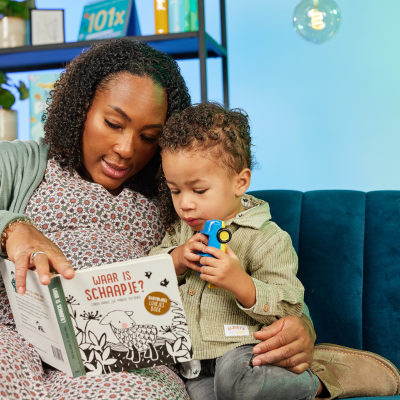 Een moeder leest haar zoontje voor uit de Babybijbel