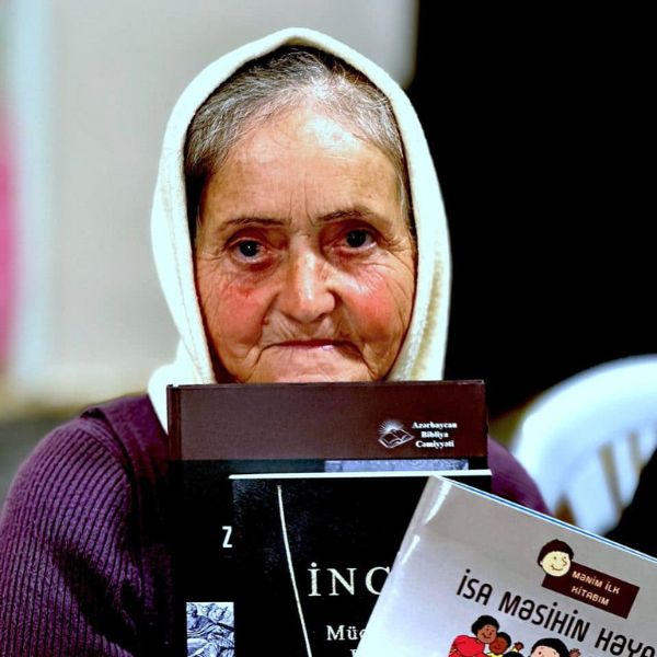 Oude dame toont de Bijbels die ze heeft gekregen.