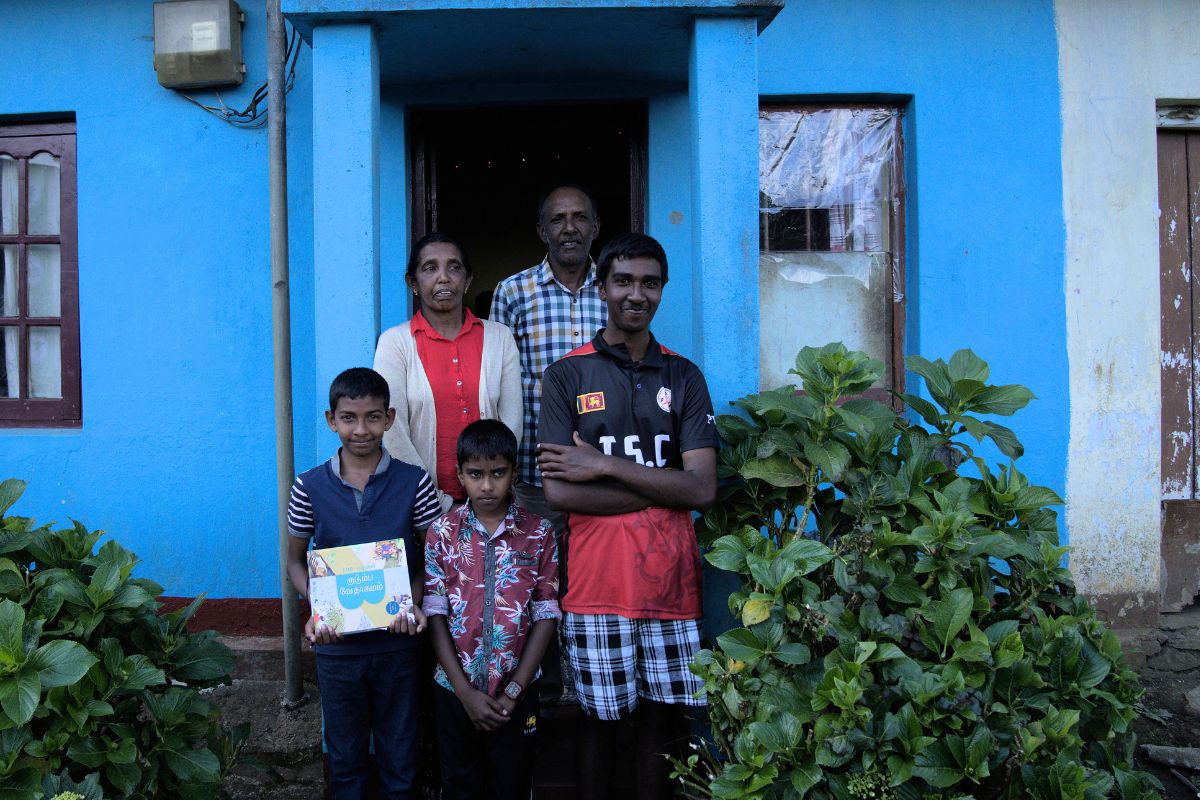 Moeder, vader en drie broers staan voor hun huis in Sri Lanka.