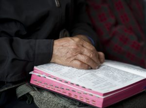 Chinese Bijbel met handen van oudere